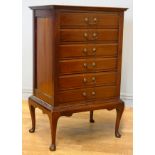 An Edwardian mahogany six height music chest of drawers, having drop down drawer fronts with brass