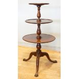 A 19th century three tier circular dumb waiter, the lower two revolving, raised on a tripod base