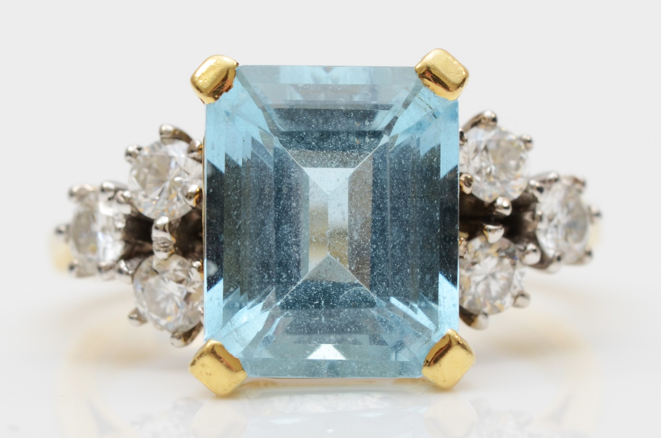 An 18ct gold aquamarine and diamond dress ring, claw set with a step cut stone, 11 x 9mm,