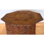 An Anglo-Indian octagonal hardwood occasional table, on folding base, with intricate relief carved