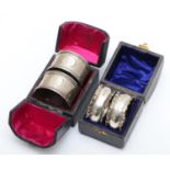 A silver pair of napkin rings, Birmingham 1916, with engine turned decoration, 43gm, case and