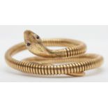 A vintage 9ct gold and steel sprung coiled snake bracelet, Birmingham 1979, with garnet set eyes,