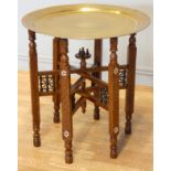 An Indian brass top benares style table on folding hardwood base with mashrabiya panels and mother