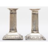 A silver pair of Corinthian column desk candlesticks, by Dixons, Sheffield 1934, raised on swag