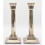 A silver pair of octagonal column candlesticks, London 1935, Jubilee mark, raised on square bases,