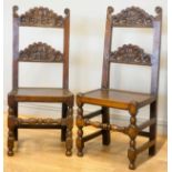 A pair of 18th century oak Yorkshire chairs, the definite back crests with voluted scrolls and