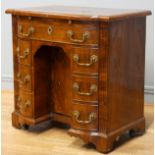 A George II walnut kneehole desk, burrbanded quarter-veneered shaped top with moulded edge above