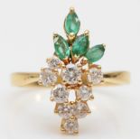 A gold, emerald and diamond dress ring, stamped 750, claw set with brilliant cut stones, colour
