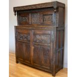 Charles II and later oak press or court cupboard, dated 1688, the canopy top with inverted finials