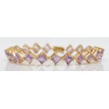 A 9ct gold and amethyst line bracelet, stamped 375, claw set with square cut stones, 19.5cm, 14gm