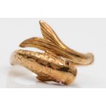 An 18ct gold coiled fish ring, London 1977, lacking carat mark, with textured body and ruby eyes,