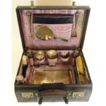 A ladies leather travel case, containing a silver and glass dressing table set, London 1918, with