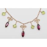 An Edwardian rose gold almandine garnet and peridot fringe necklace, unmarked, 42cm, 7.2gm