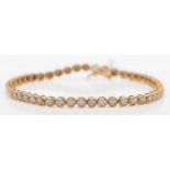 A 9ct gold and diamond line bracelet, illusion set with 51 stones, 18cm, 5.7gm