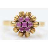 An 18K gold and ruby cluster ring, with scroll border, Q, 4.8gm