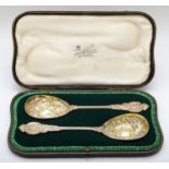 A Victorian silver pair of embossed and chased serving spoons, London 1898, cast handles with