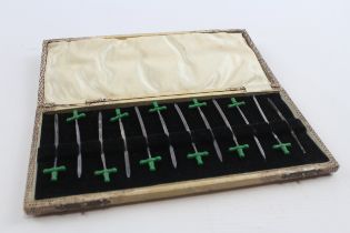 A silver and green plastic set of 12 pickle swords, Birmingham 1928, lacking one handle, case