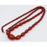 A cherry red amber Bakelite graduated bead necklace, 32 - 8mm beads, 92cm, 76gm