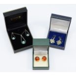 A pair of silver and amber ear studs, a pair of silver and peridot ear rings and a silver necklace.