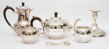 A four piece electroplated tea service, a pair of sugar tongs and a candlestick