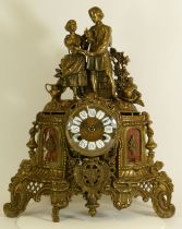 A gilt brass Ormolu style mantel clock, the scrolling floral case with inset marble panels housing a