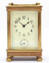 An early 20th century brass alarm carriage clock, with 8 day movement striking on bell. 13cm tall,