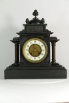 A Victorian slate mantel clock, the 8 day movement striking on gong. 33cm tall.