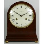 An English mahogany Comitti mantel clock of oval form, with an 8 day movement striking on bell,