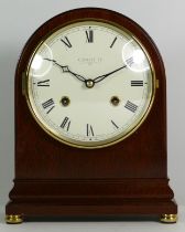 An English mahogany Comitti mantel clock of oval form, with an 8 day movement striking on bell,