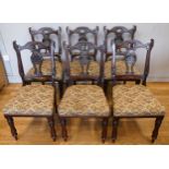 A set of six Victorian rosewood dining chairs, having ornate carved shaped back with carved centre