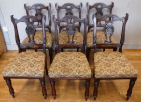 A set of six Victorian rosewood dining chairs, having ornate carved shaped back with carved centre