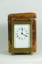 An early 20th century brass carriage clock, having an 8 day movement, with traveling case and key.