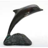 A bronze model of a dolphin on wave, 12cm tall.