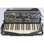 A cased Hohner Verdi III piano accordion.