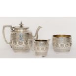 A Victorian silver plated three piece tea set with repoussé images and chased decoration in the