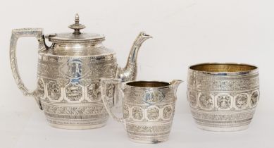 A Victorian silver plated three piece tea set with repoussé images and chased decoration in the