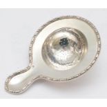 A continental silver tea strainer with cast beaded rim, bearing control mark, 13 x 9cm, 67gm.