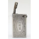 A rectangular metal petrol lighter with chased floral and scroll decoration, 4 x 2 x 2.5cm.