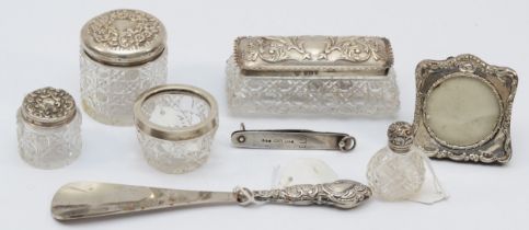 A group of silver topped glass dressing table bottles, and a silver handled shoe horn.