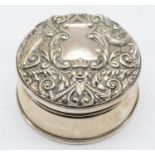 An Elizabeth II silver trinket box with lined interior and embossed decoration to the lid,