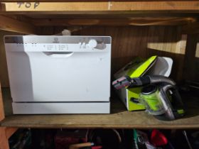 An Indesit table top dishwasher and a G-Tech hand held vacuum cleaner.