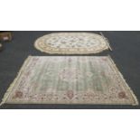 A modern oval cream ground carpet, 345 x 230, together with a green ground floral carpet, 200 x 290,