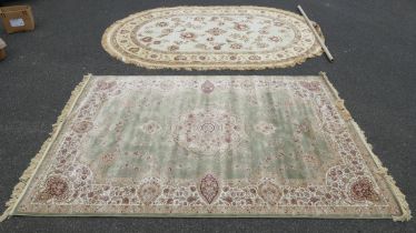 A modern oval cream ground carpet, 345 x 230, together with a green ground floral carpet, 200 x 290,