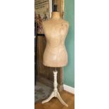 An early 20th century dressmakers mannequin, raised on a trypod stand.