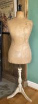 An early 20th century dressmakers mannequin, raised on a trypod stand.