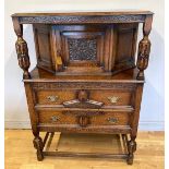 An Edwardian oak court cupboard with inlaid carved foliate detail, the upper section fitted with