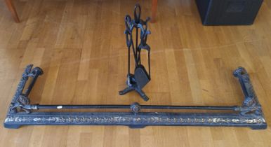 A cast metal black painted fire curb, 146cm and a set of metal fire irons.