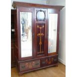 An Edwardian mahogany double wardrobe, having Art Nouveau inlaid decorated panels flanked by bevel