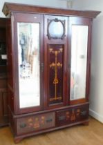 An Edwardian mahogany double wardrobe, having Art Nouveau inlaid decorated panels flanked by bevel