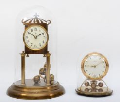 Two brass anniversary clocks with glass domes, tallest 29cm.